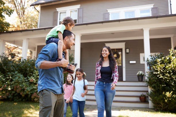 Happy family standing in front of their Metairie home.