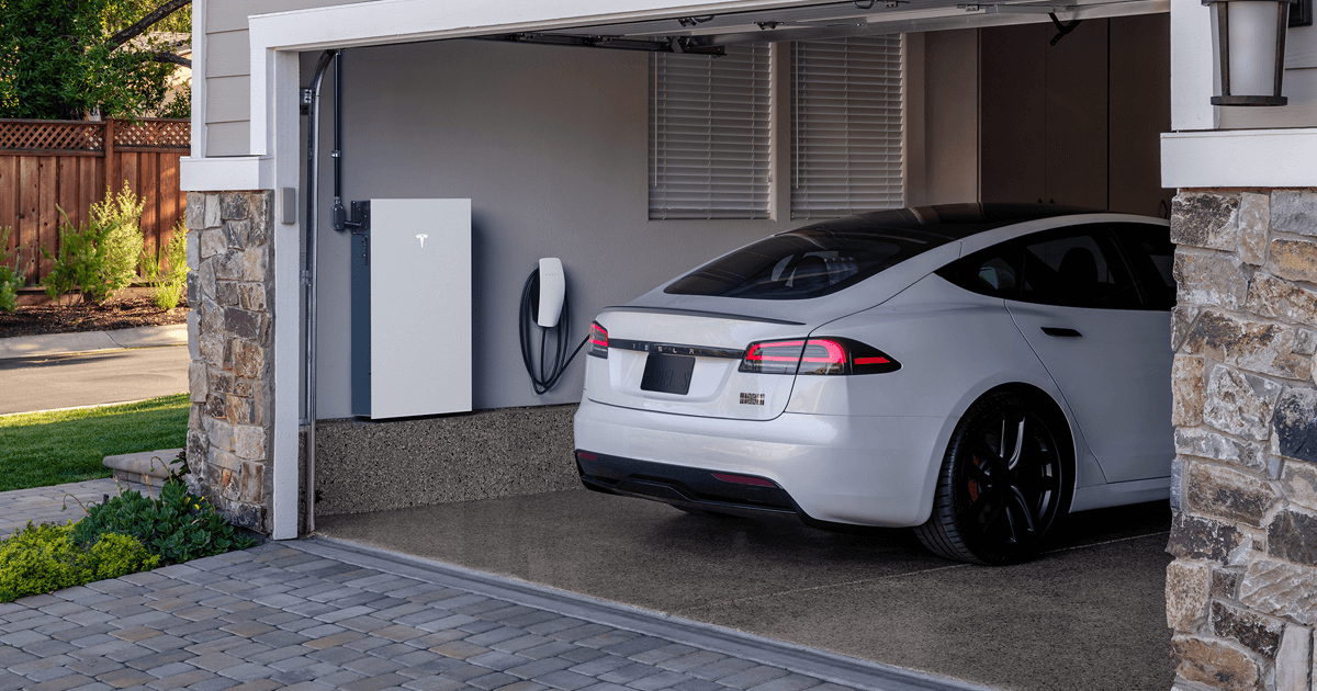 Homeowner charging their electric vehicle in the driveway using a home EV charging station.