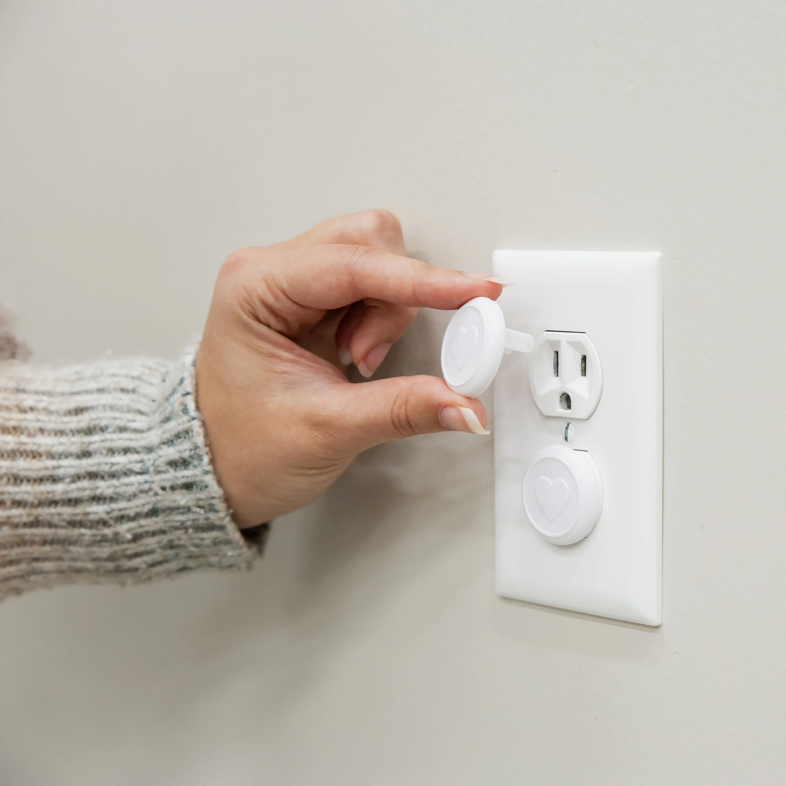 Close-up of a childproofed electrical outlet with a safety cover installed, highlighting steps to protect children from electrical hazards at home.