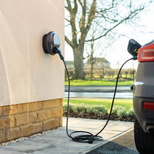 Electric car plugged into a residential charging station.