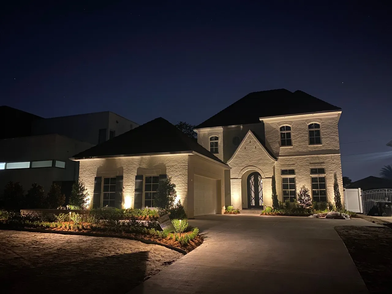 Landscape lighting installed in Metairie yard highlighting trees, pathways, and architectural features at night.