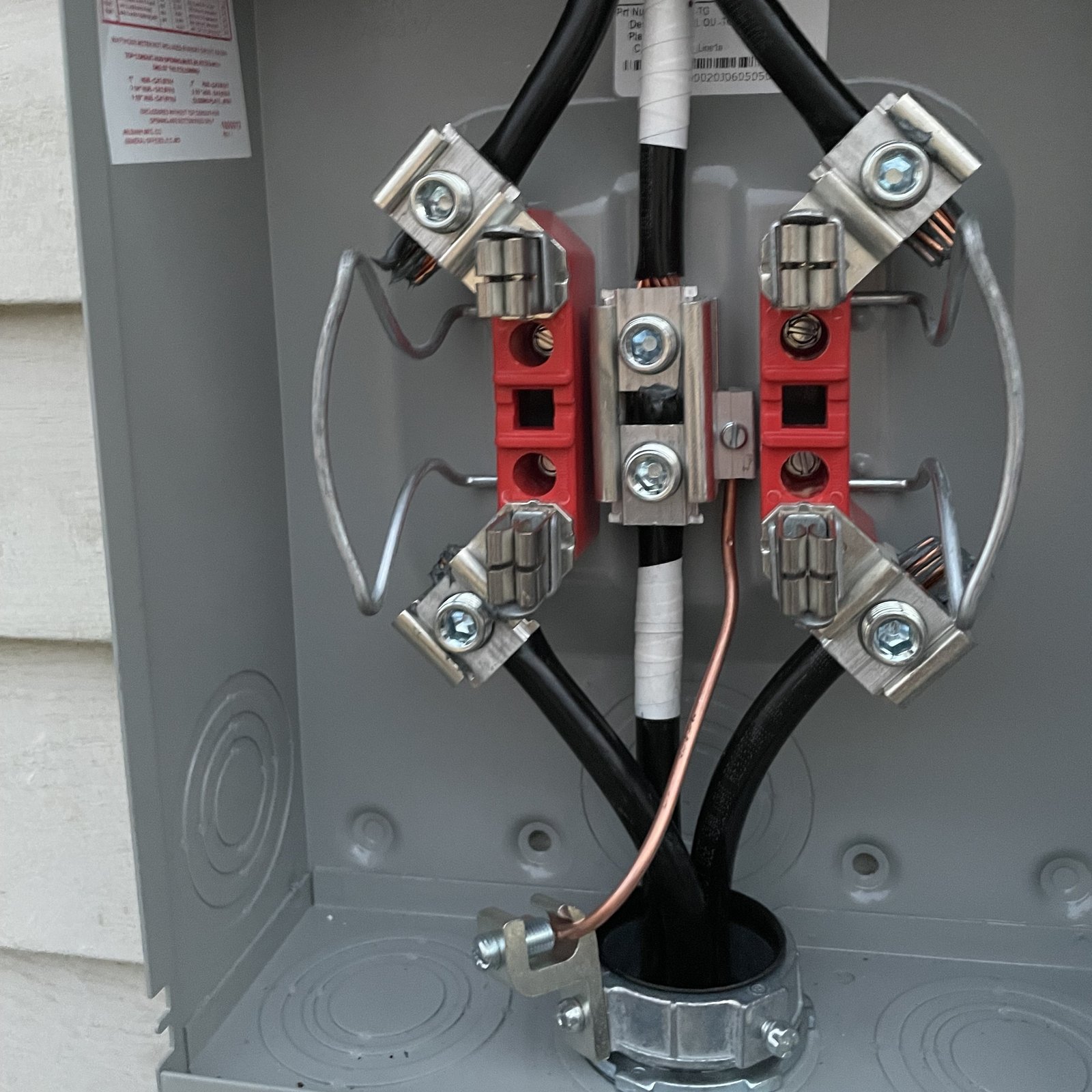 Interior components and service conductors inside a residential electric meter socket.