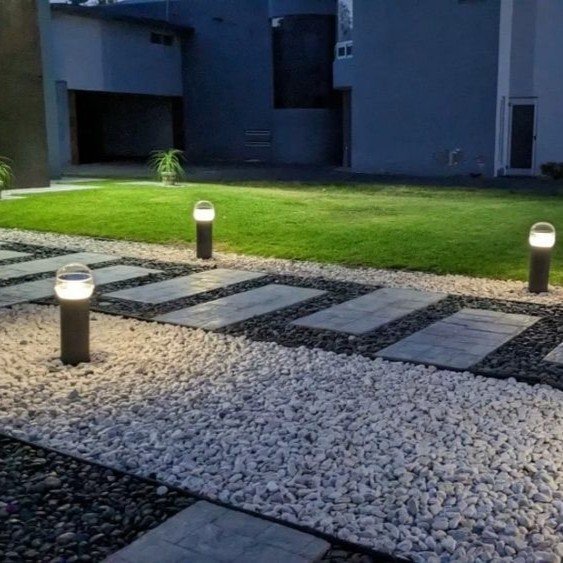 Landscape lighting installed in Metairie yard highlighting trees, pathways, and architectural features at night.