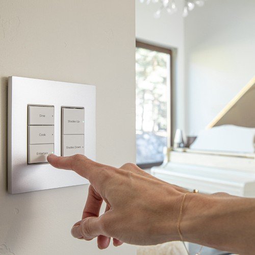Homeowner flipping on a light switch in a well-lit room, highlighting professional electrical services for reliable home lighting installations.