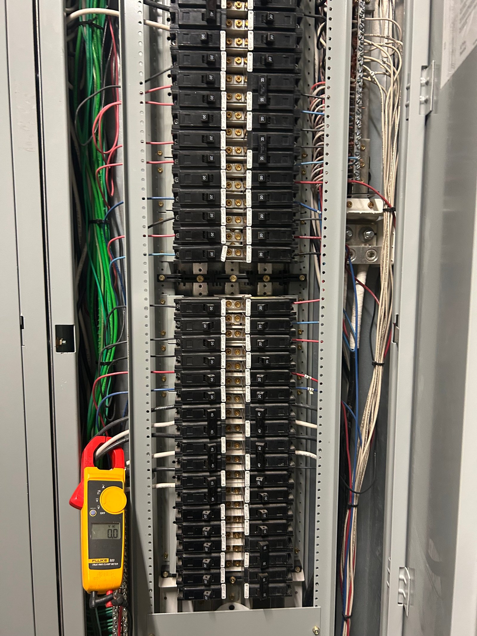 Licensed electrician inspecting and testing a commercial electrical panel for businesses in Metairie and New Orleans.