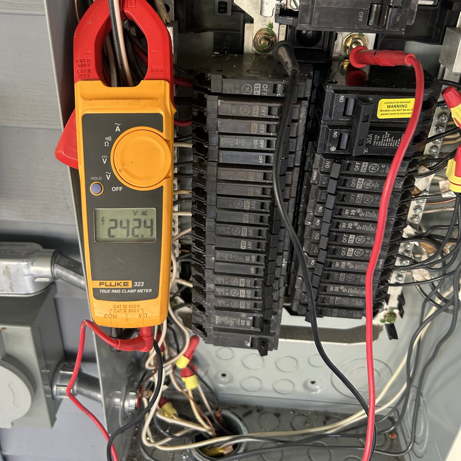 Licensed electrician testing a residential electrical panel with a digital meter during troubleshooting in Metairie and New Orleans.