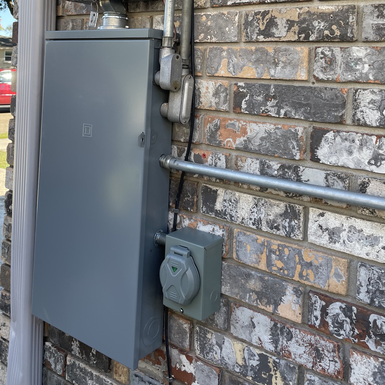 Exterior generator inlet installed beside residential electrical equipment