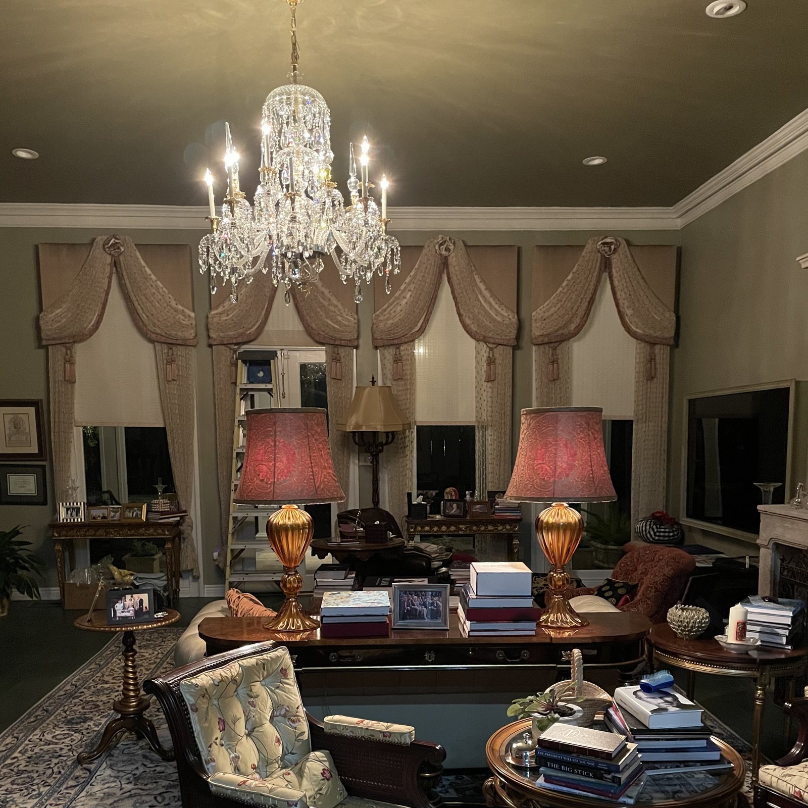 Crystal chandelier and layered lighting illuminating an elegant living room